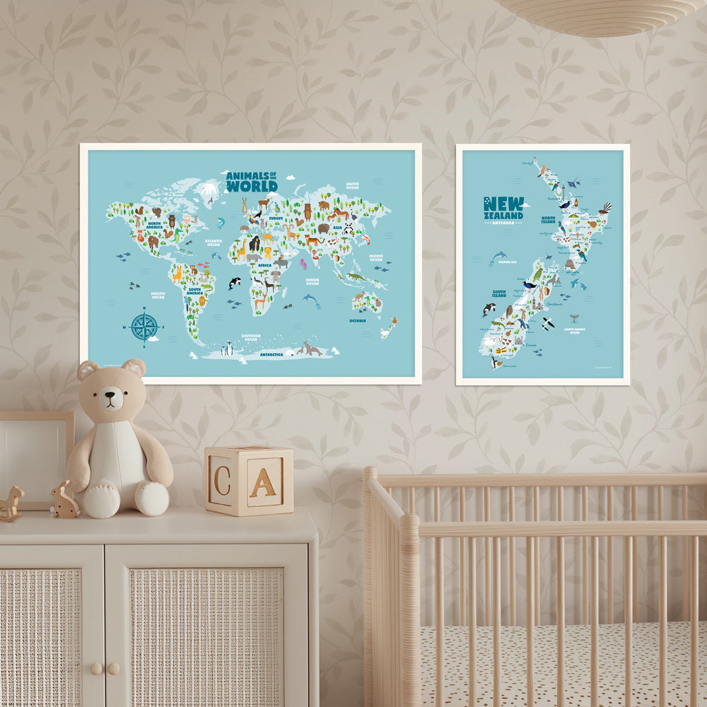 One animal world map and one New Zealand map in frames on a wall above a crib and cabinet with a teddy bear and wooden blocks. Nursery room decor - Bluish Nest Art Studio
