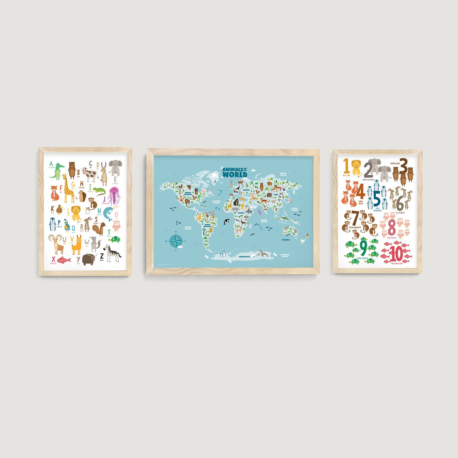 Three framed kids and nursery educational wall art prints on a wall, including an animal world map, alphabet and numbers charts - Bluish Nest Art Studio