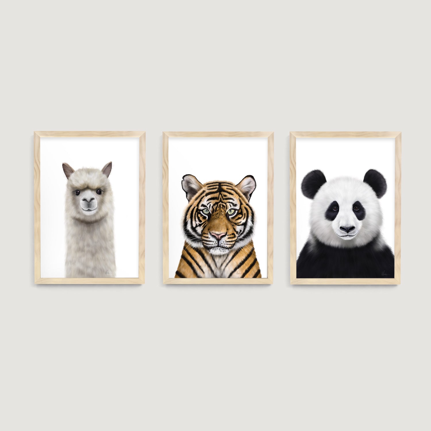 Three framed nursery and children wall art prints of an alpaca, tiger, and panda on a white wall  - Bluish Nest Art Studio