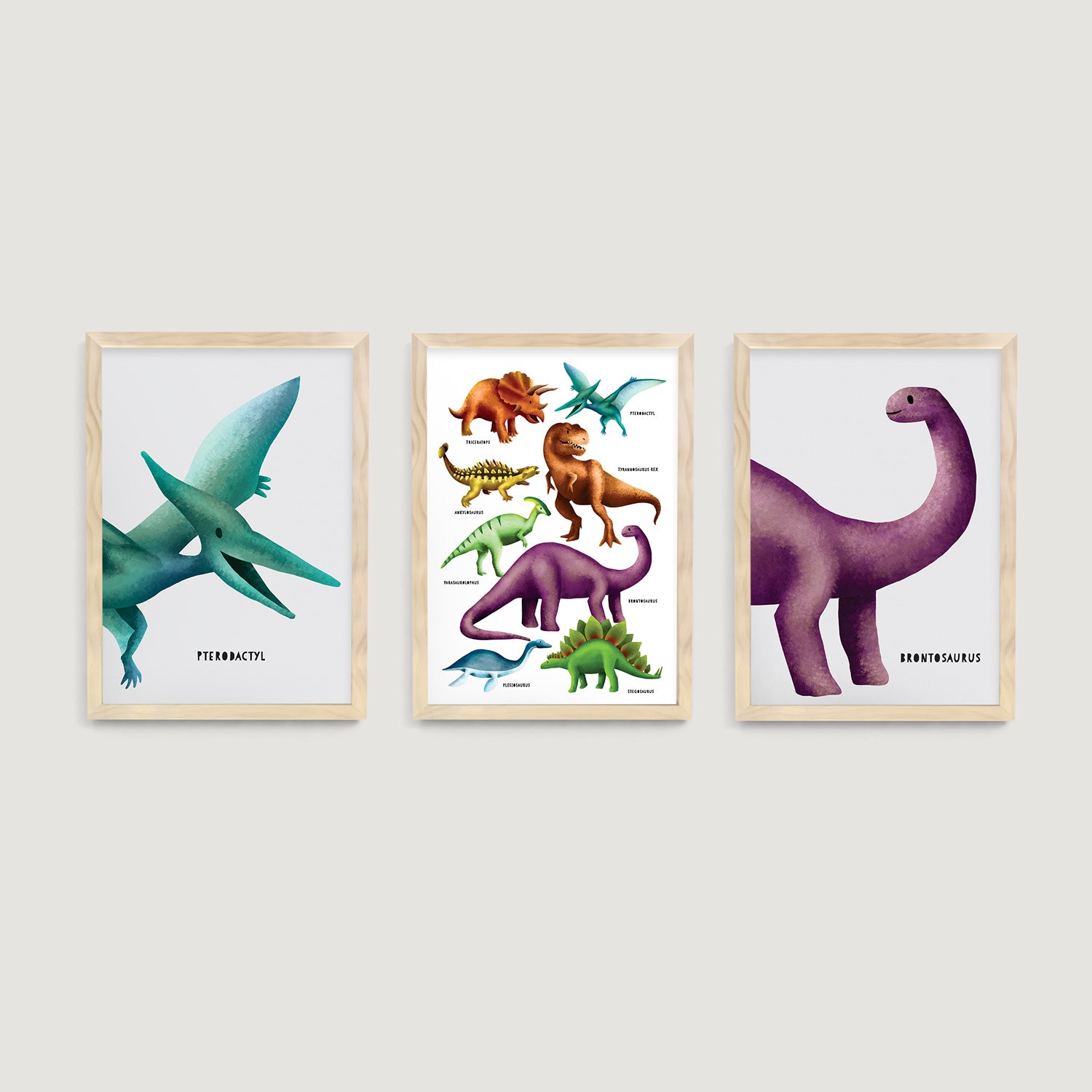 Three framed nursery and kids wall art prints of dinosaurs, pterodactyl and brontosaurus on a white wall  - Bluish Nest Art Studio