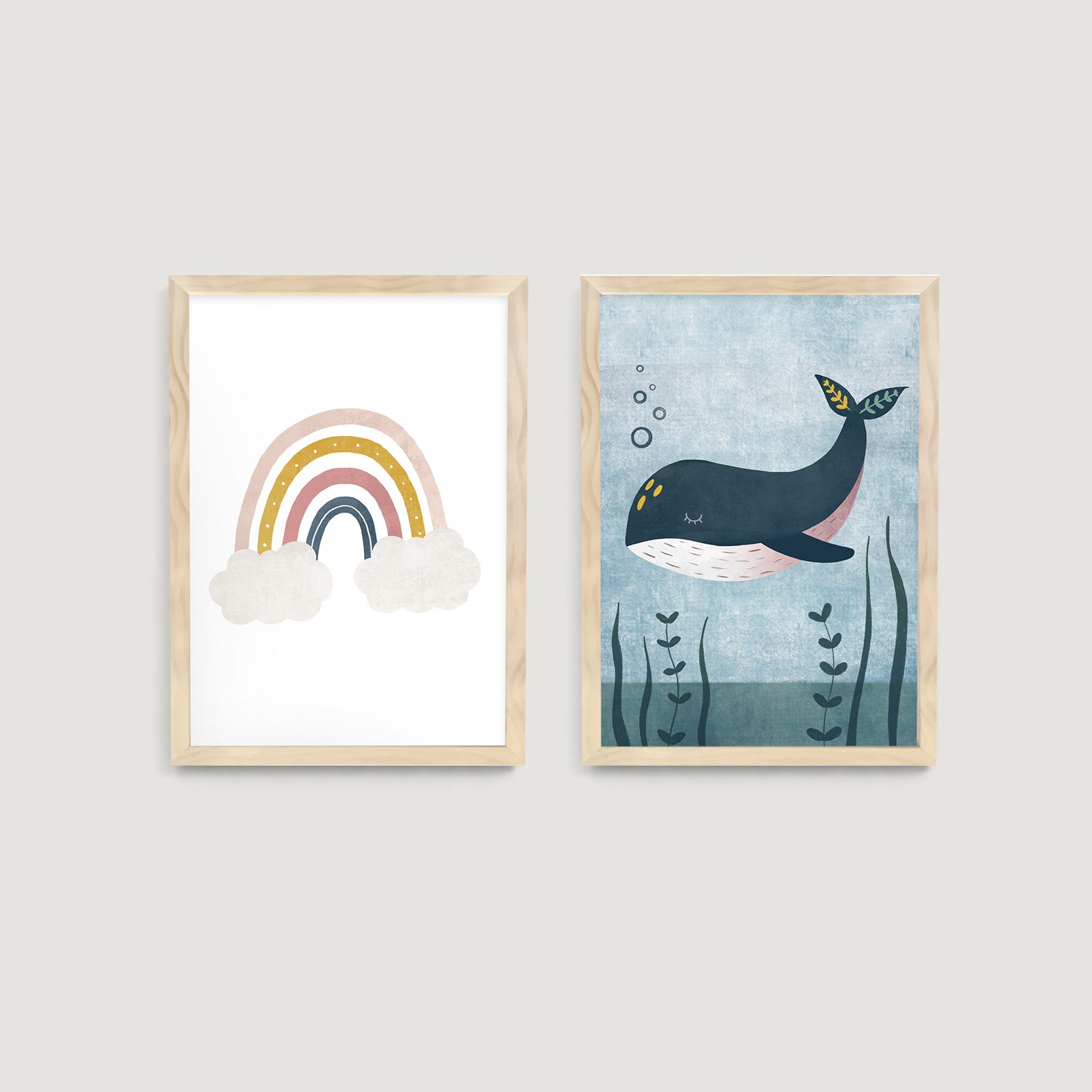 Two framed children and nursery wall art prints on a wall, one with a rainbow and clouds, the other with a whale - Bluish Nest Art Studio