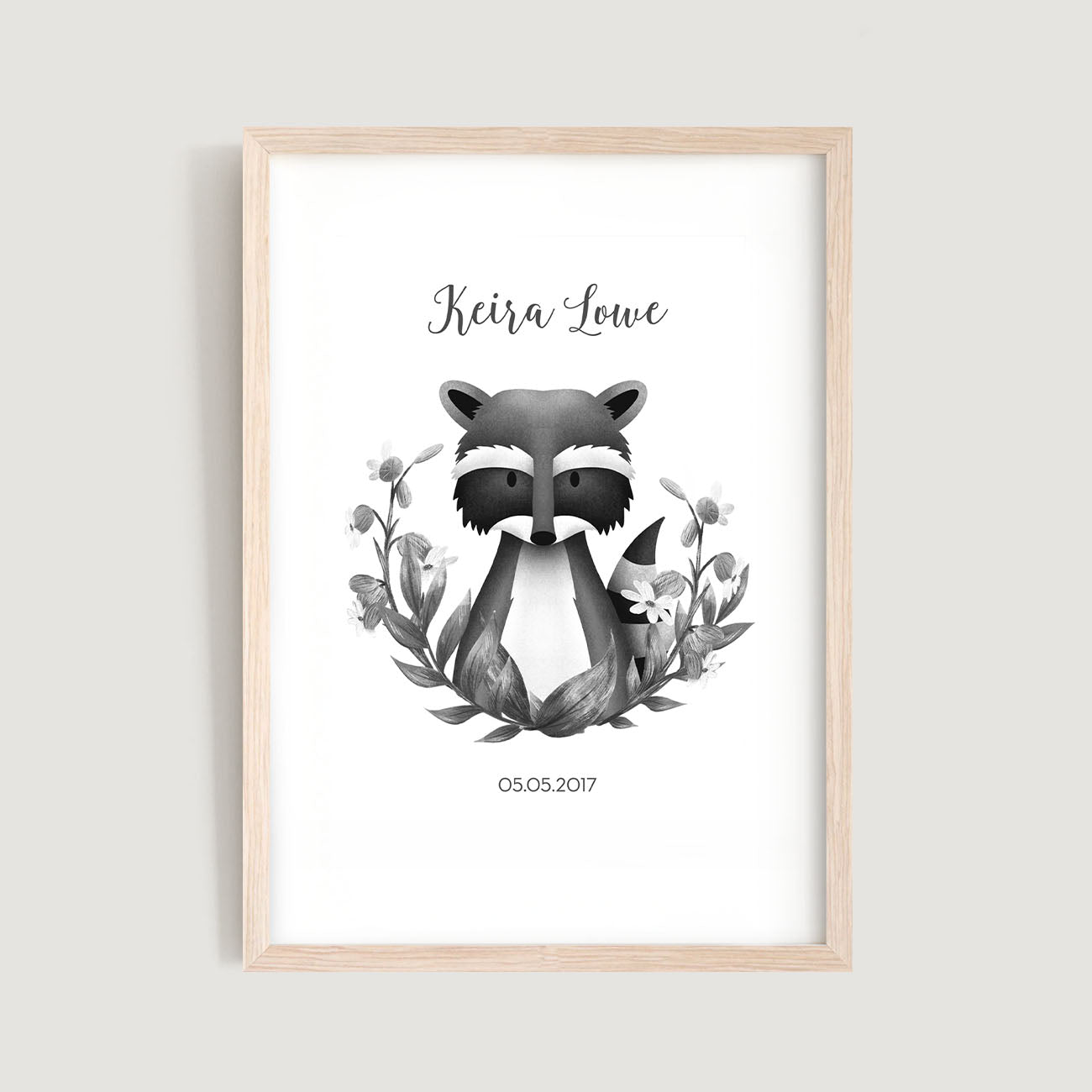 A framed personalised birth baby and kids wall art print of a woodland racoon in black and white, with flower wreath and text in white background - Bluish Nest Art Studio