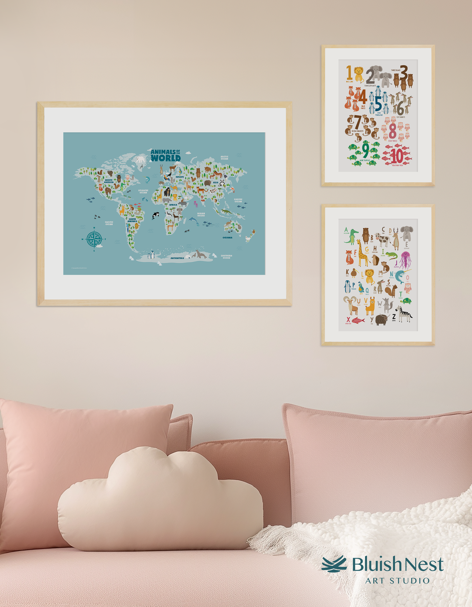 A set of three framed nursery and kids wall art prints consisting of animal world map, educational alphabet and numbers, in a bedroom with couch - Bluish Nest Art Studio