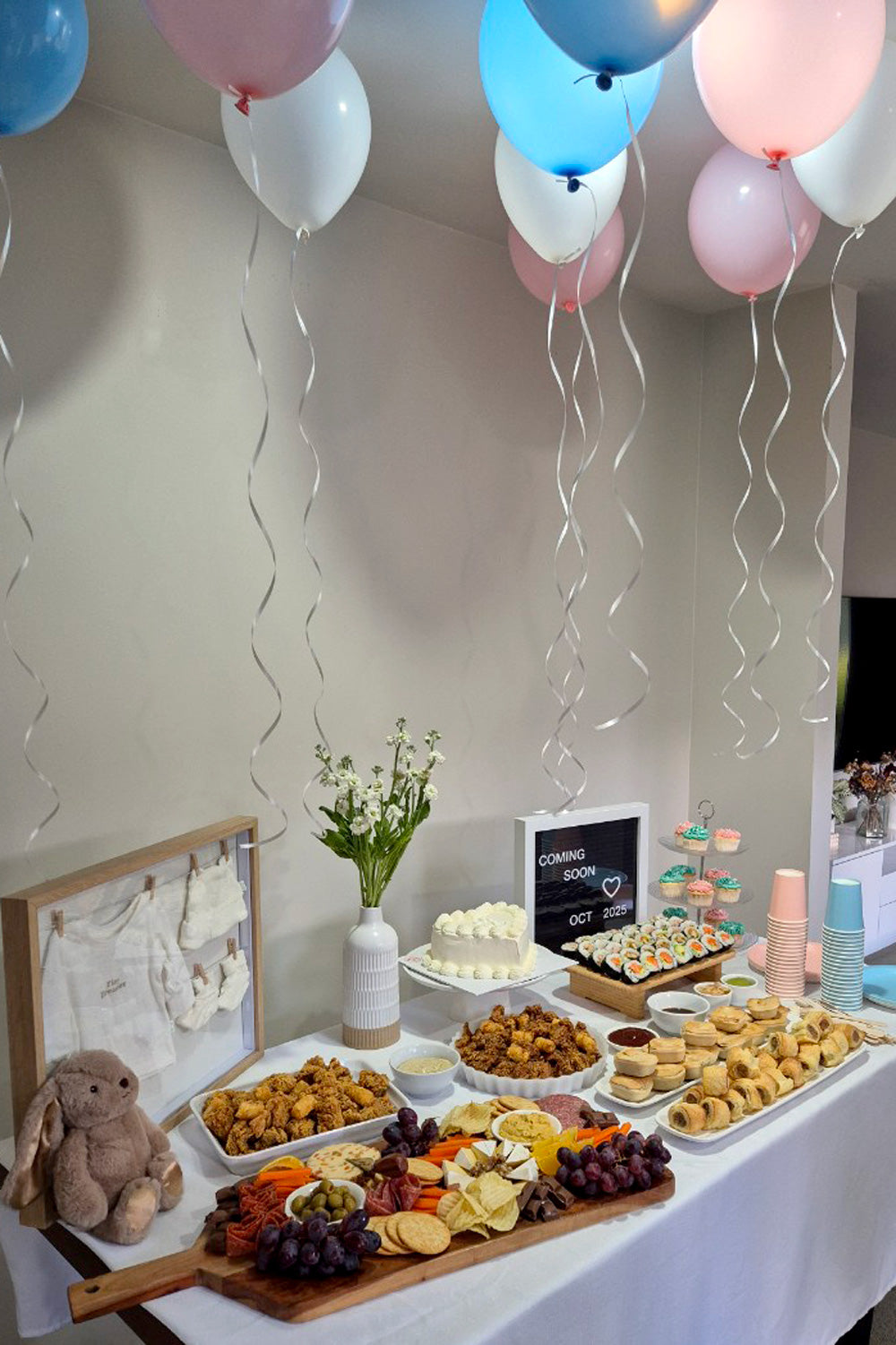 Shower party. Decorated room with balloons, a dessert table, and floral arrangements.